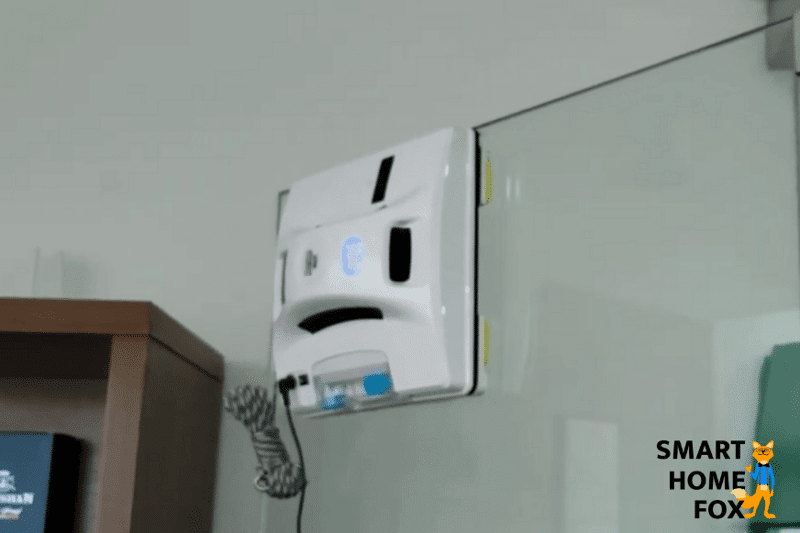 Робот для мытья окон протирает безрамное окно и останавливается перед краем